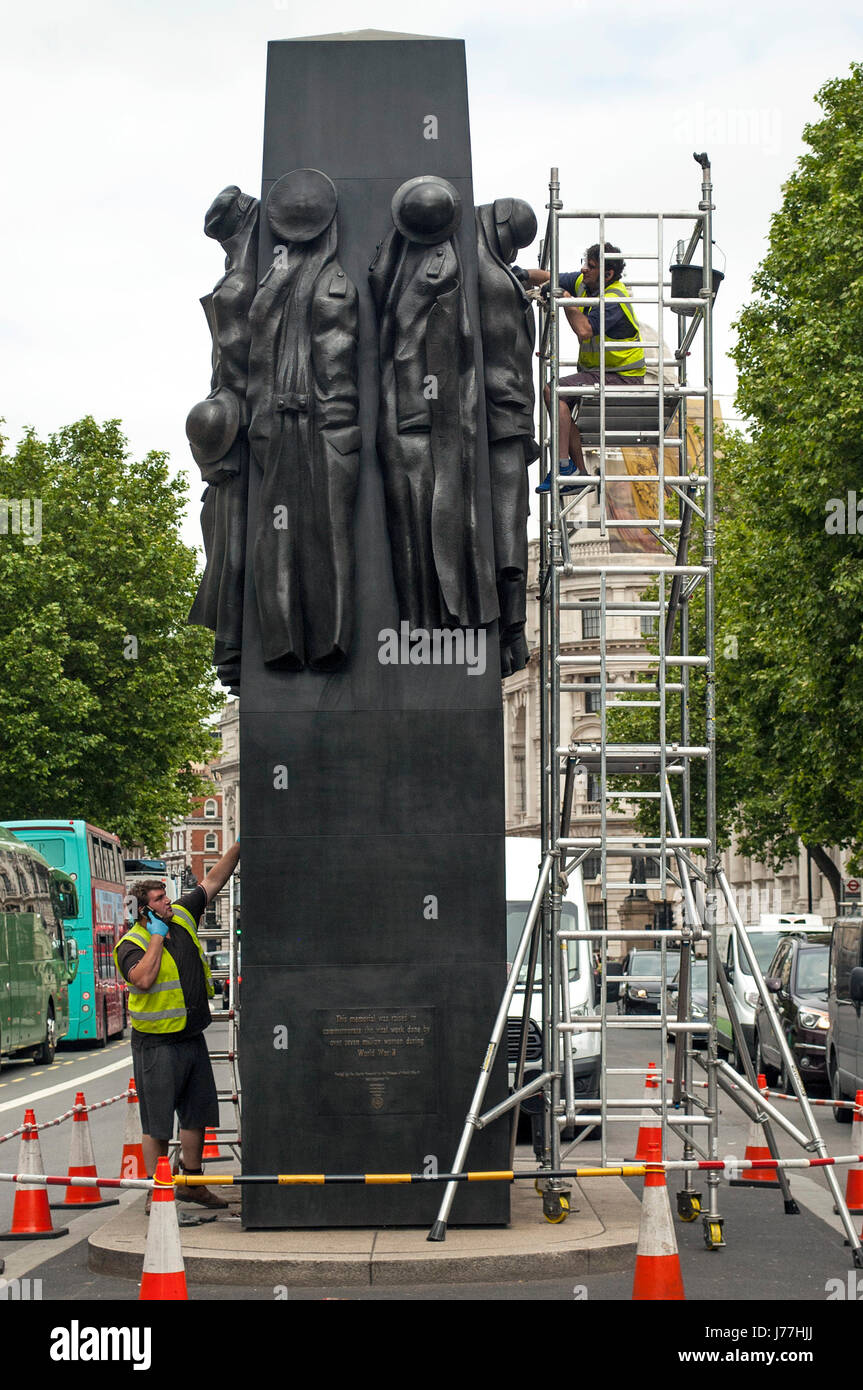 London, UK. 23rd May, 2017. 'Women of World War II' memorial in Whitehall sculpted by John W. Mills,  gets a spring clean as the Union Flag over Downing street flies at half-mast following the terrorist boming in Manchester at the Ariana Grande concert. Credit: JOHNNY ARMSTEAD/Alamy Live News Stock Photo