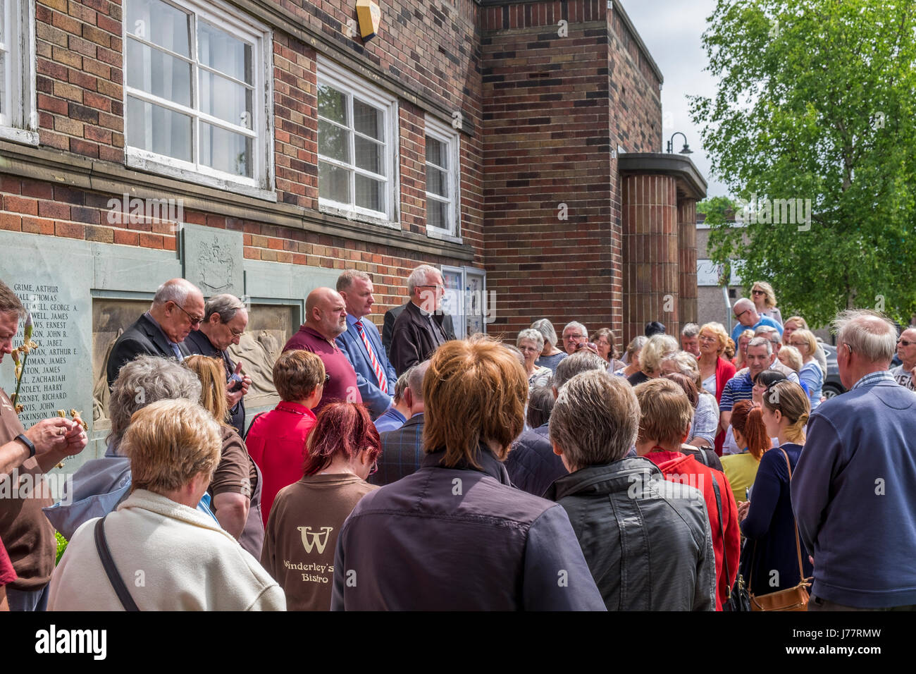 Little Lever, Bolton, England, 24th May 2017. Local priest leads members of the public in prayers for the victims and relatives of the Manchester bombing, local councillors, Sean Hornsby, Rees Gibbon, both Ukip members, Canon Ian Anthony. Members of the public, Local priest and UKIP councillors assemble to lead the general public in prayers for the family and victims of the recent Islamic State group bombing in the center of Manchester. Mike Hesp/ Alamy Live News. Stock Photo