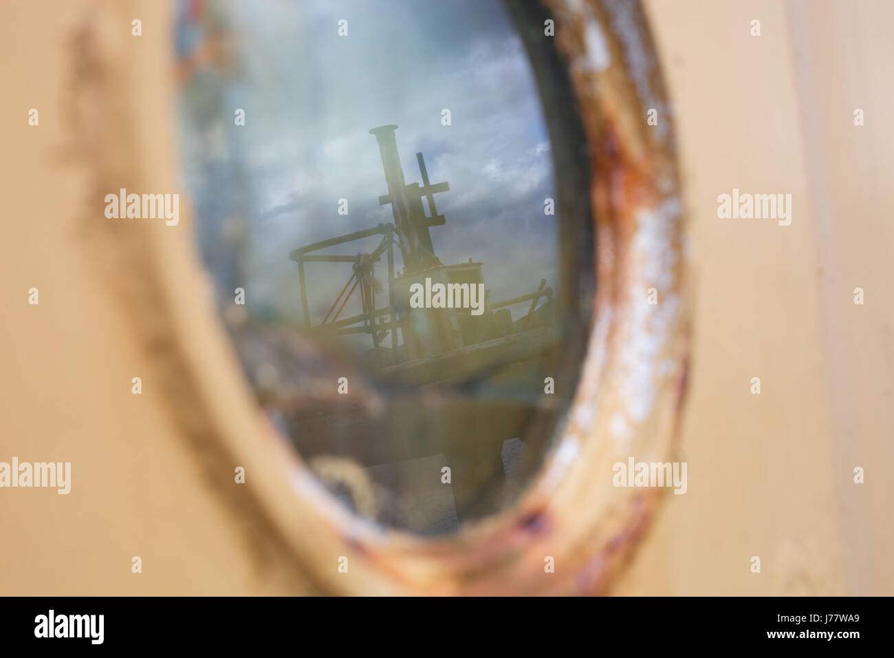 A port is reflected in the window of an ageing fishing vessel in a harbour on the isle of Skye in Scotland Stock Photo