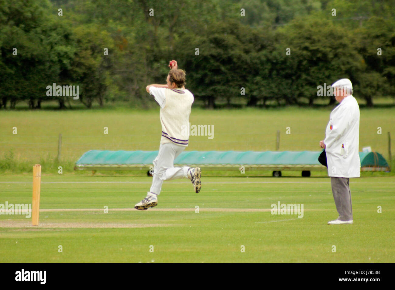 Bowler bowling infront of an umpire Stock Photo
