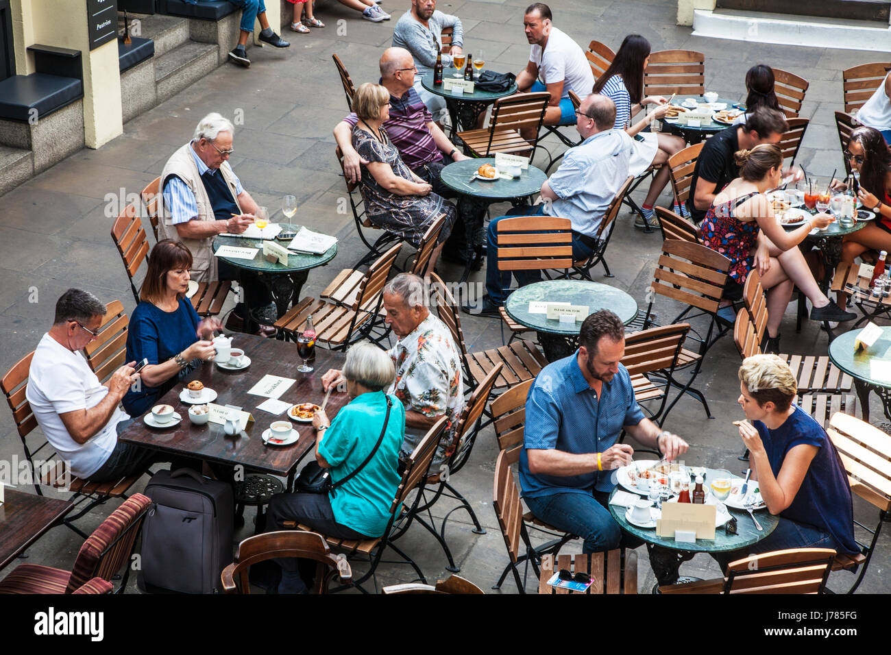 People sitting at a cafe in Covent Garden Market in London. Stock Photo
