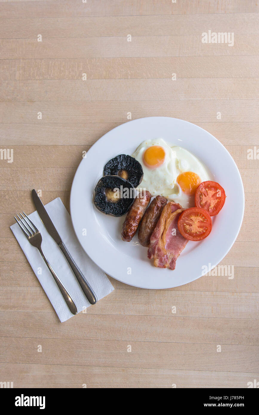 An overhead view of a full English breakfast; Food; Morning meal; Fry up; Calories; Toast; Eggs; Bacon; Sausages; Fried bread; Field mushrooms; Stock Photo