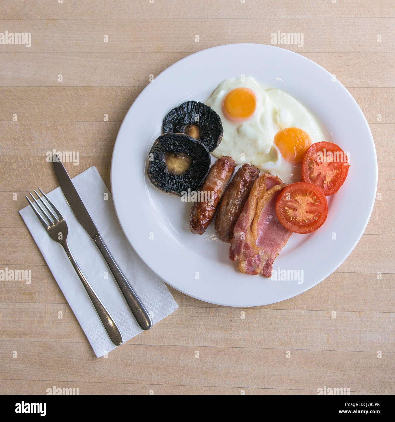 An overhead view of a full English breakfast; Food; Morning meal; Fry up; Calories; Toast; Eggs; Bacon; Sausages; Fried bread; Field mushrooms; Stock Photo