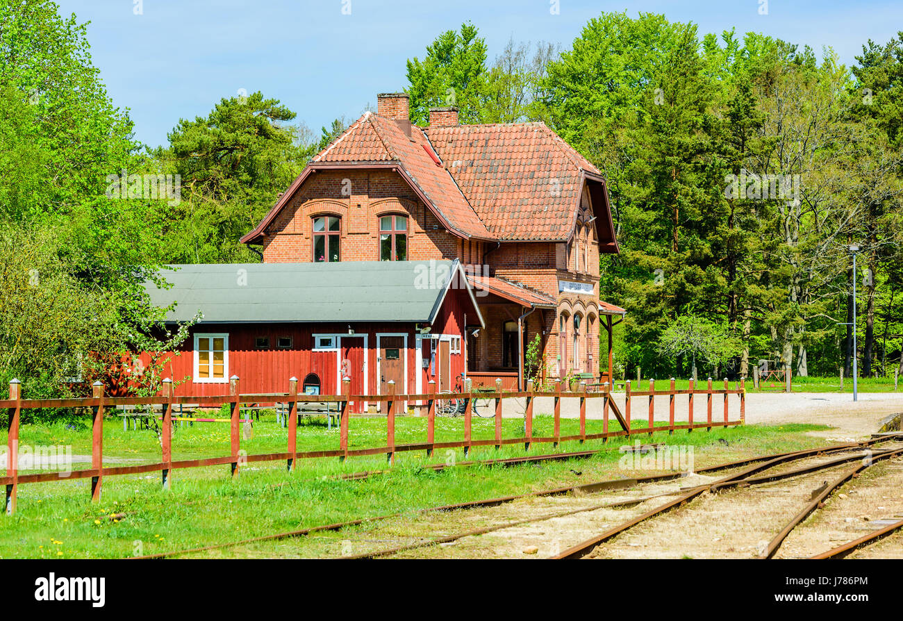 Brosarp, Sweden - May 18, 2017: Documentary of public historic place. The old vintage railroad station building with outhouse and tracks in foreground Stock Photo