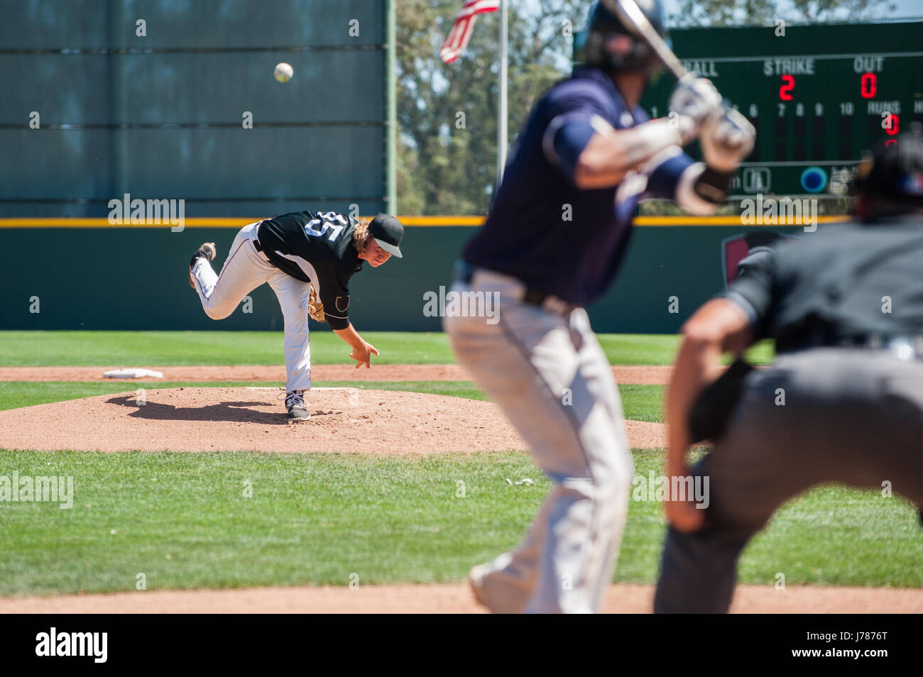 Mens' baseball pitcher throwing the curveball to the batter Stock Photo