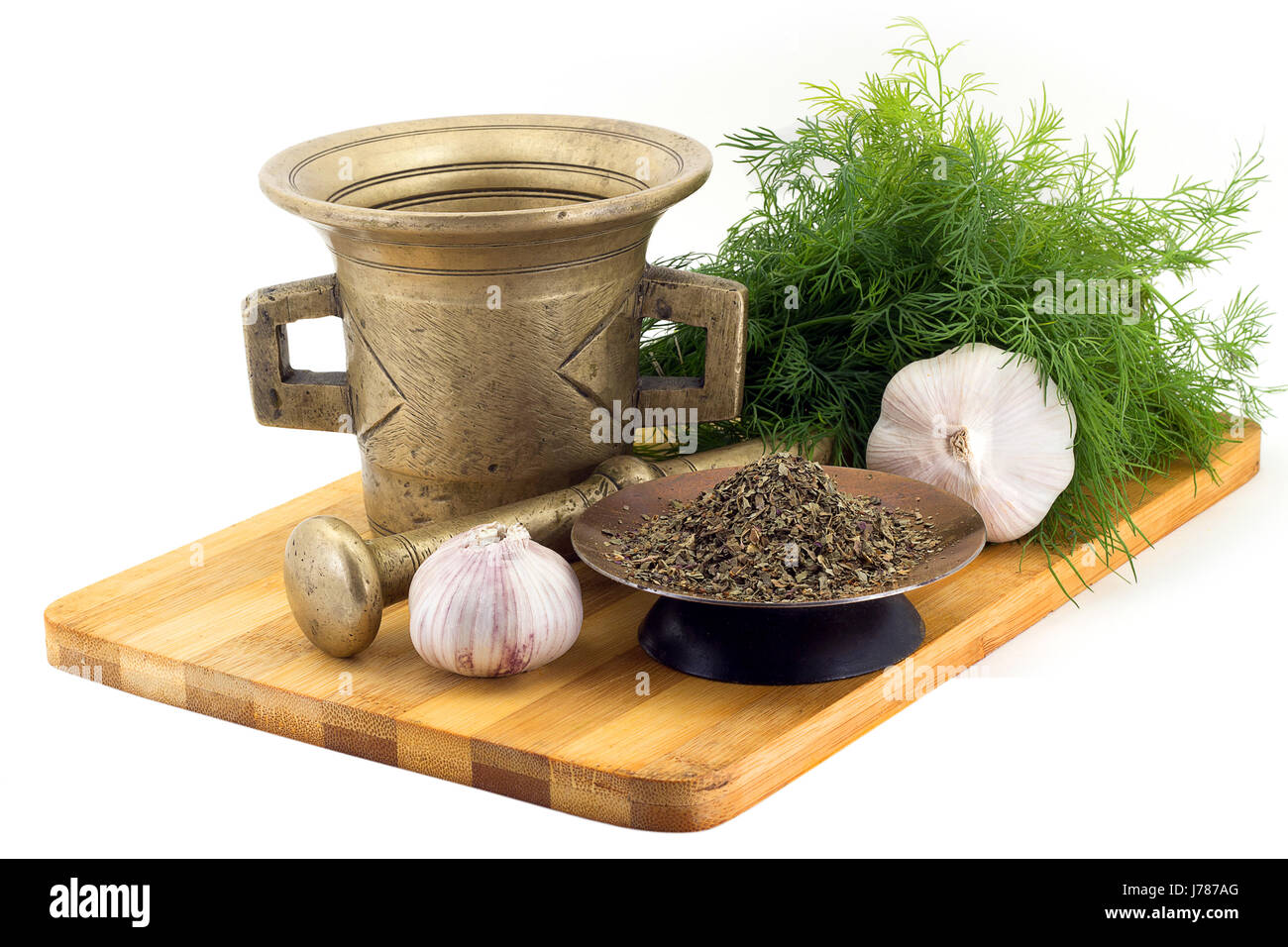 Still Life Spices, Basil ,marigold staminas in a copper vase on a wooden board on a background of a stern stupa for grinding spices, bunches of dill a Stock Photo