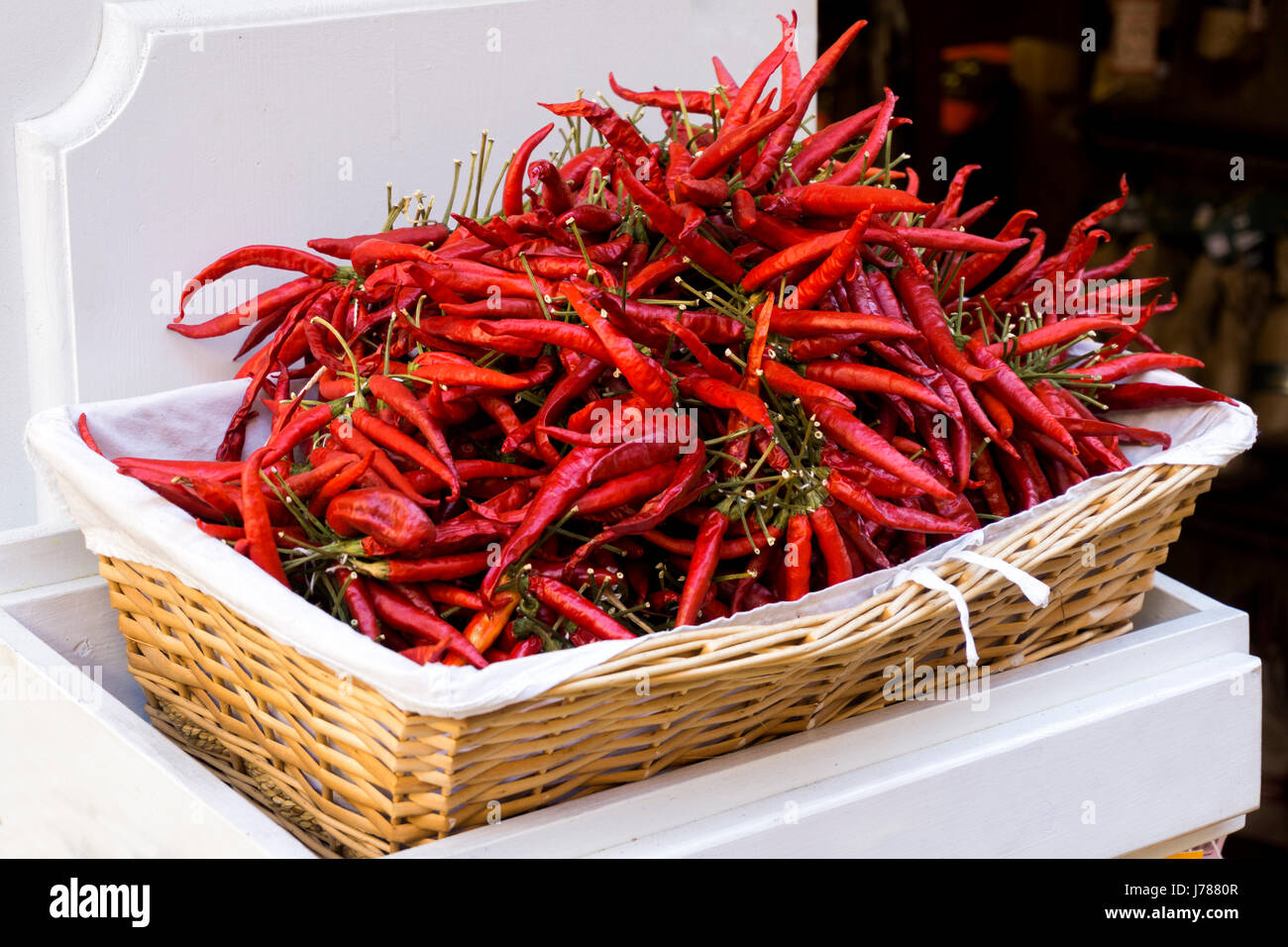Red dry chili peppers in a straw basket Stock Photo