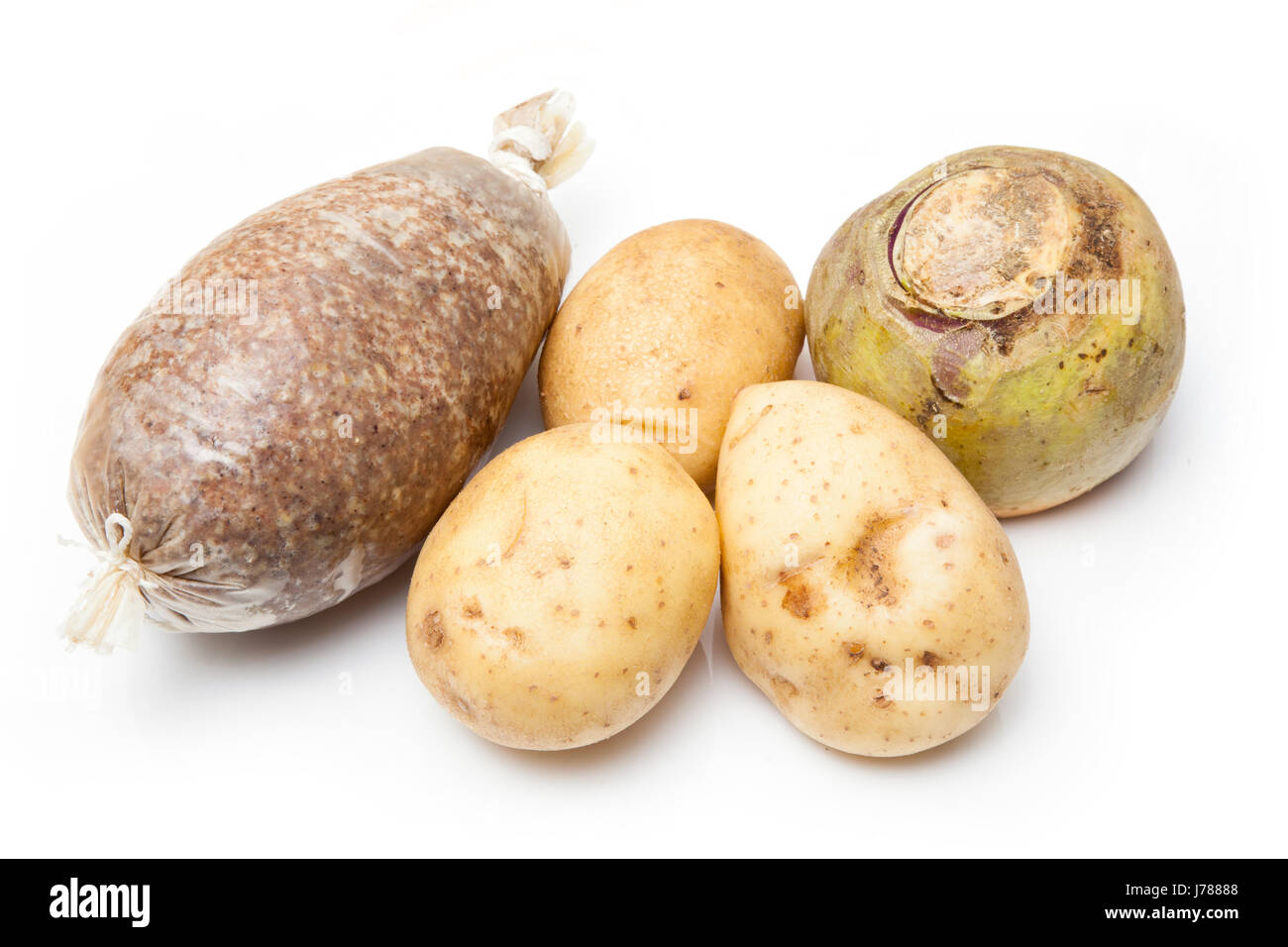 Traditional Scottish Haggis with potatoes and turnip uncooked isolated on a white studio background. Stock Photo
