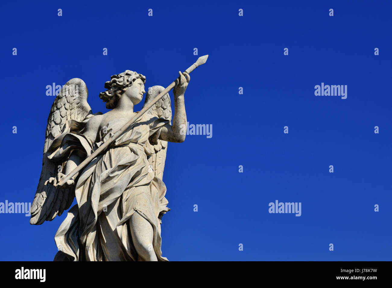 Angel statue holding the Holy Lance of Longinus on Sant'Angelo Bridge in Rome (with blue sky and copy space) Stock Photo