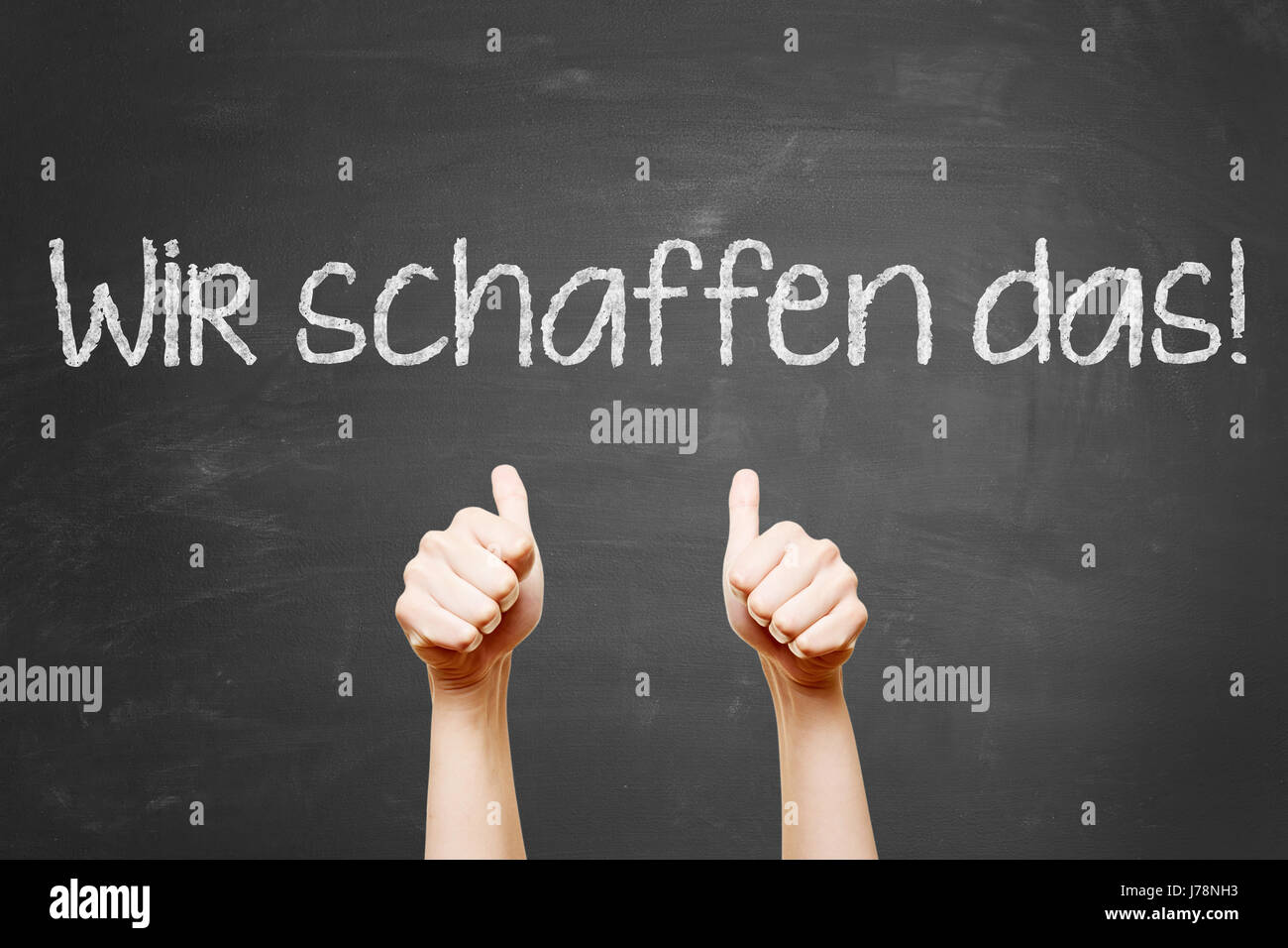German slogan 'Wir schaffen das' (we can do it) with thumbs up on blackboard Stock Photo