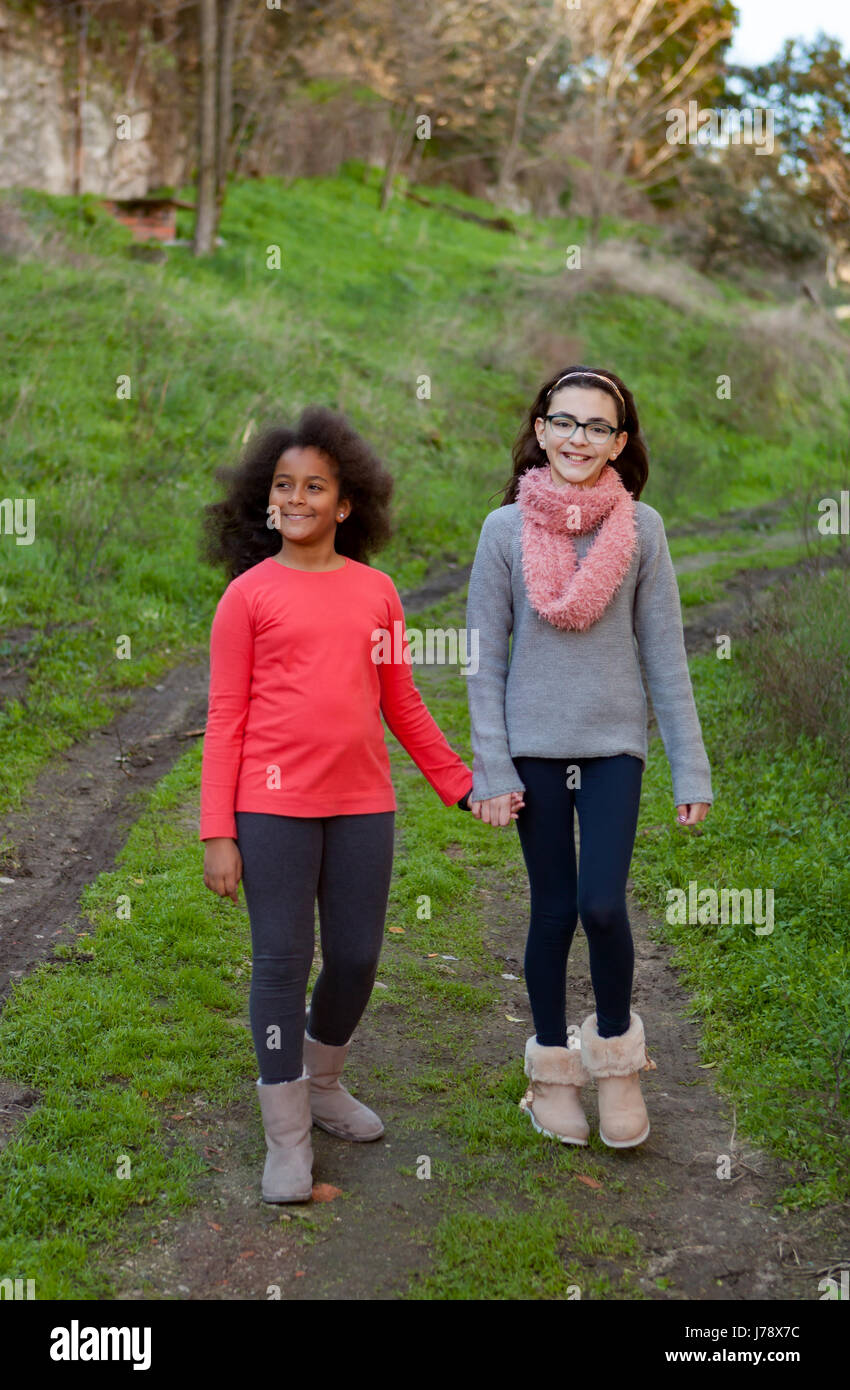 Two beautiful girls taking a walk by a green field Stock Photo - Alamy