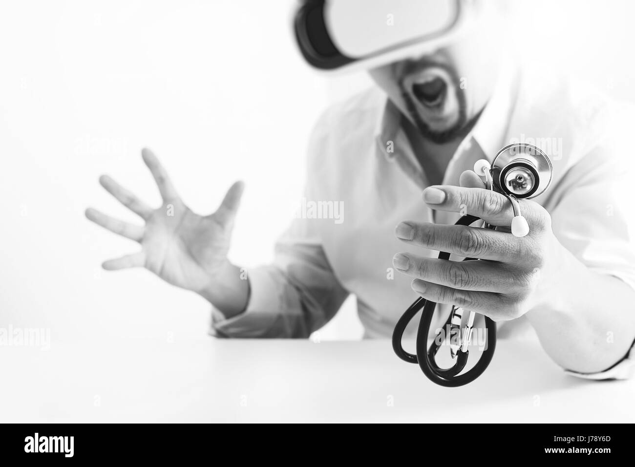 smart doctor wearing virtual reality goggles in modern office with mobile phone using with VR headset,black and white Stock Photo