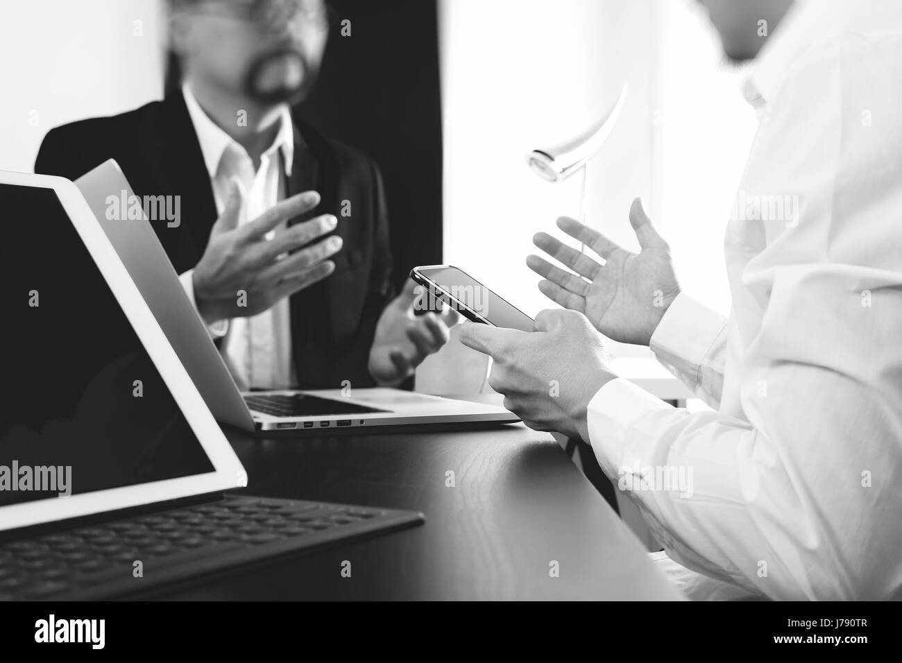 Co working team meeting concept,businessman using smart phone and digital tablet and laptop computer in modern office,black and white Stock Photo