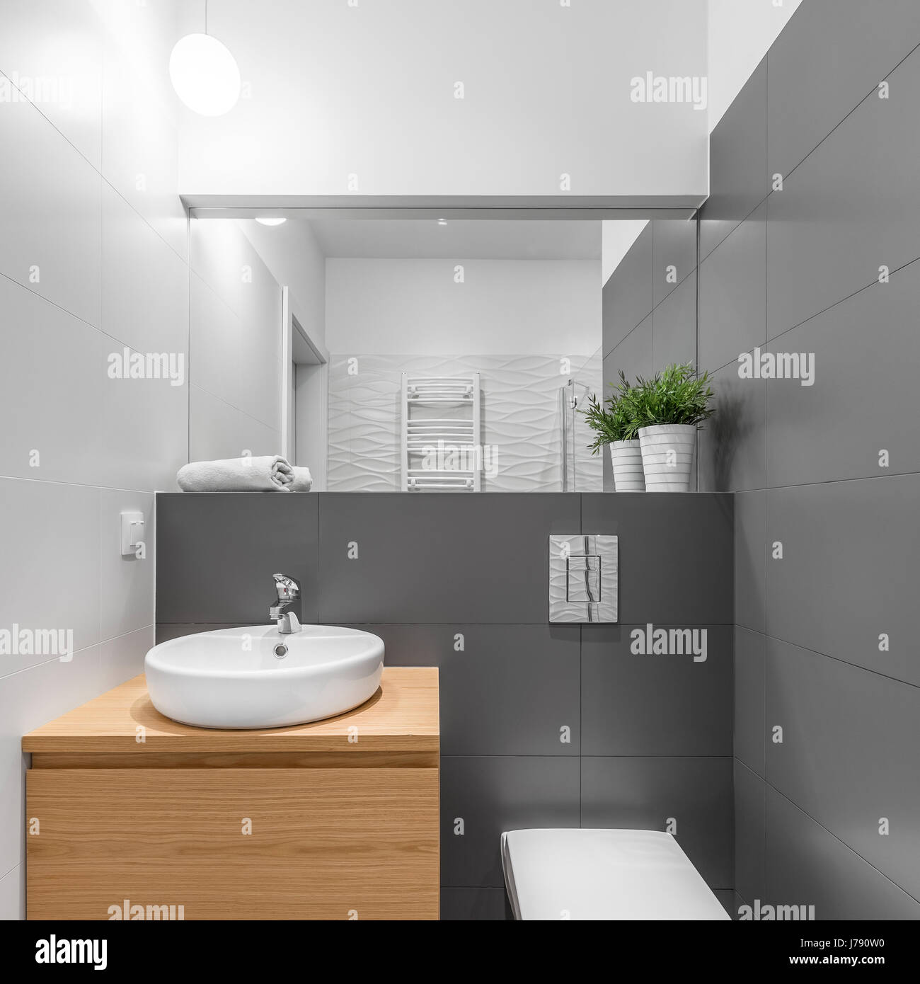 Small grey and white bathroom with wooden cabinet, round basin and ...