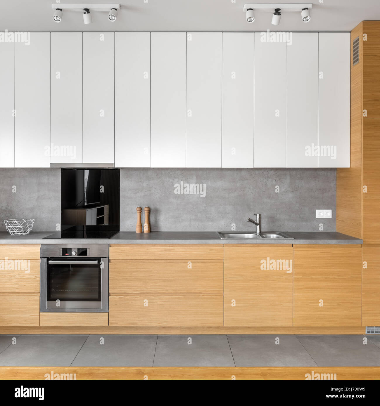 Modern kitchen with grey tiling, wooden and white cabinets, granite worktop Stock Photo