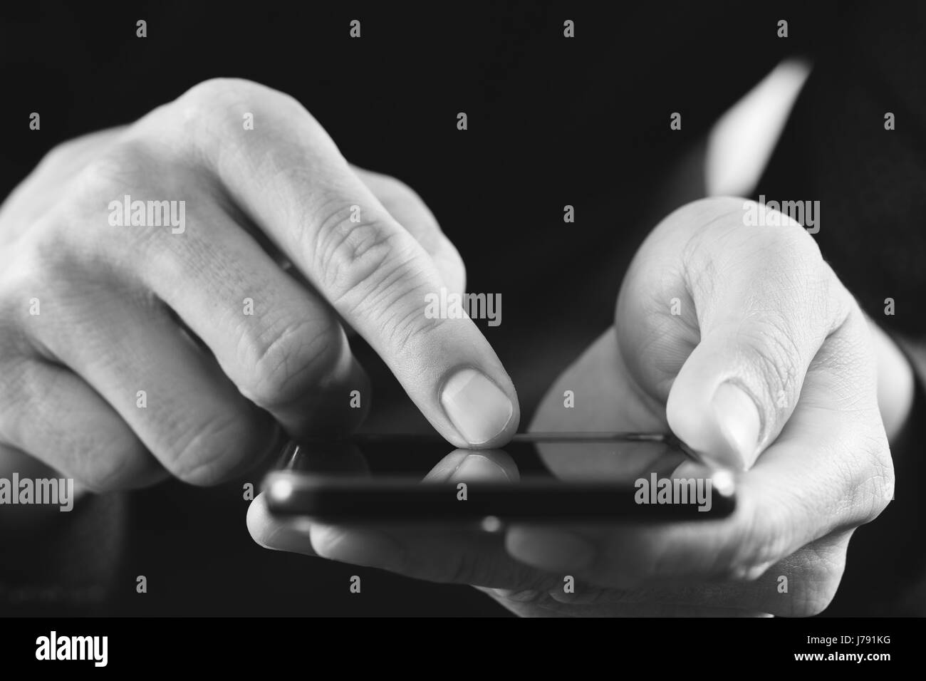 close up of businessman hand working with smart phone in modern office,black and white Stock Photo