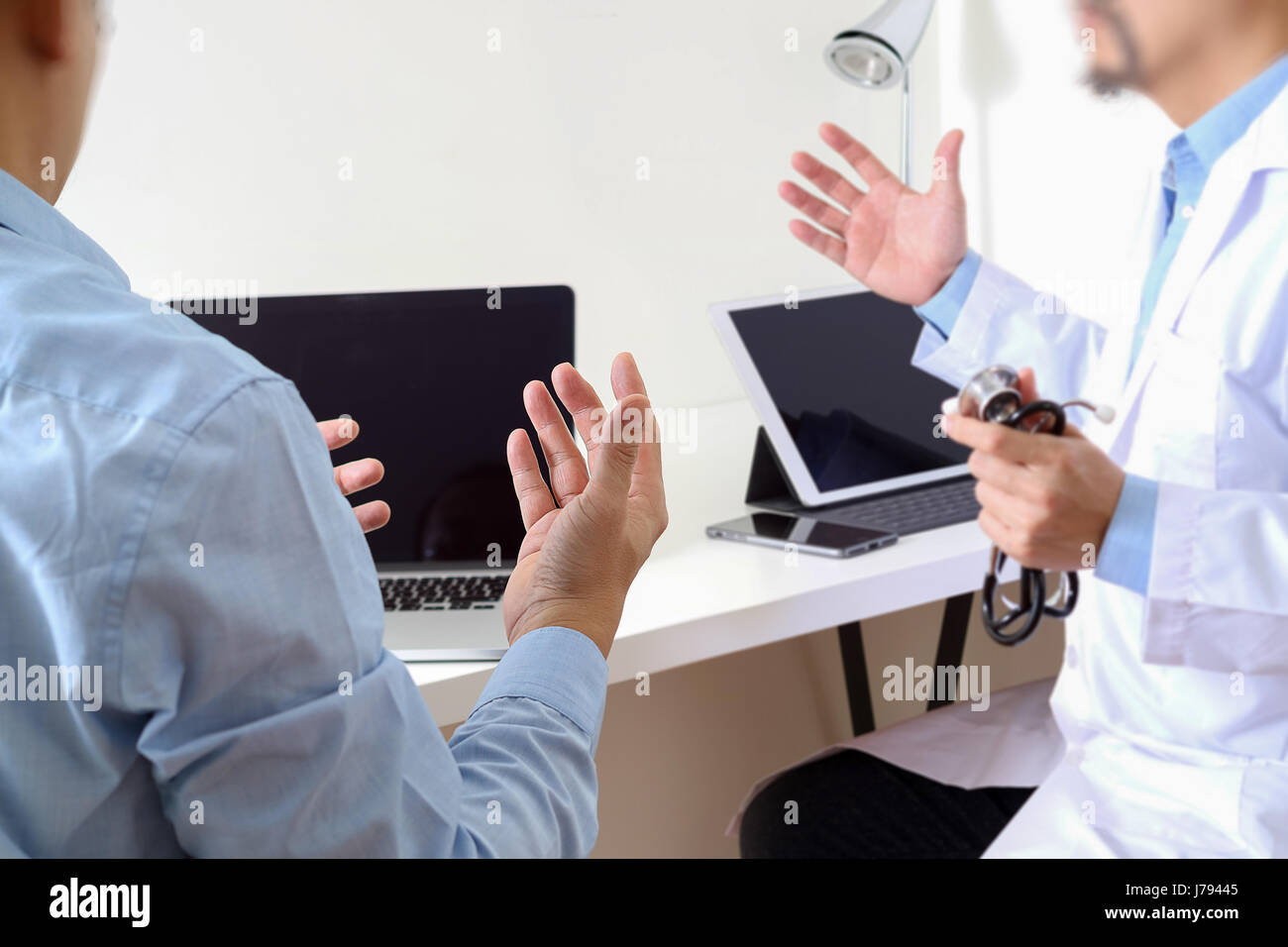 Medical doctor in white uniform gown coat consulting businessman patient having exam as Hospital professionalism concept Stock Photo