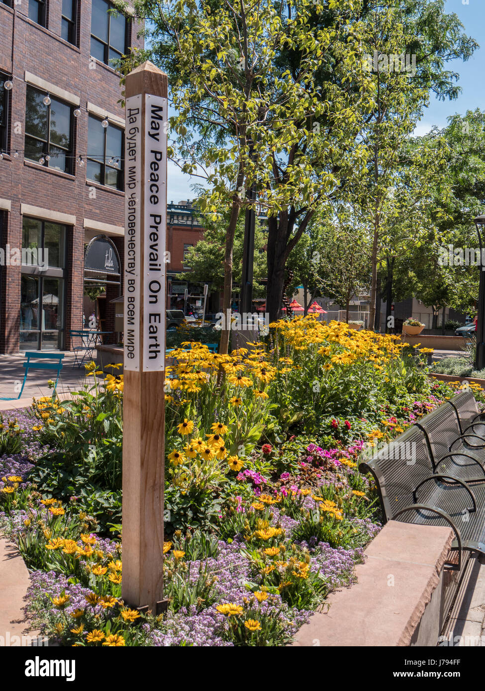 May Peace Prevail on Earth post, and garden, Old Town Square, Fort Collins, Colorado. Stock Photo