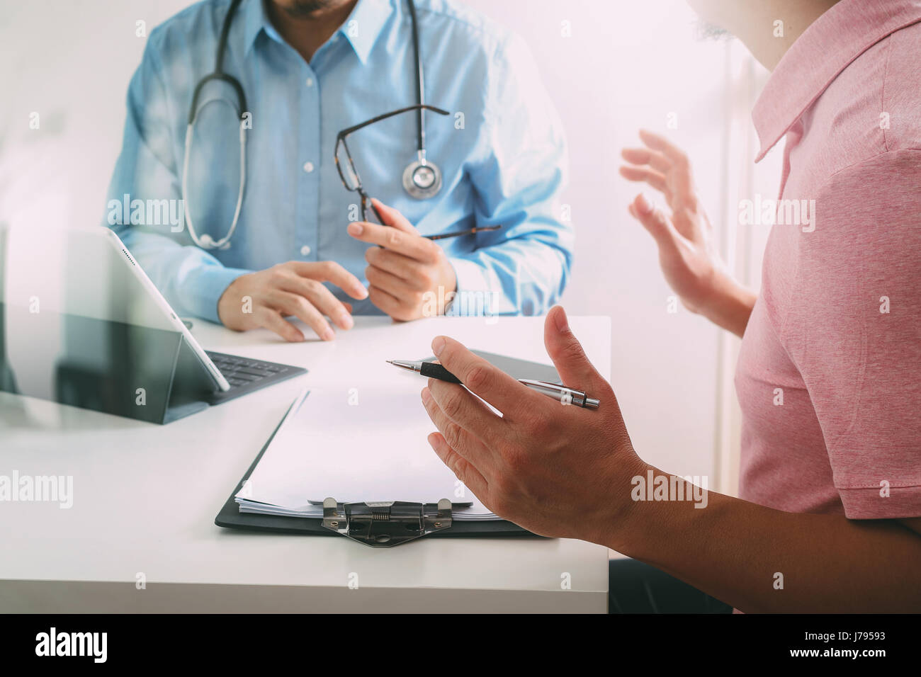 Medical doctor using mobile phone and consulting businessman patient having exam as Hospital professionalism concept Stock Photo