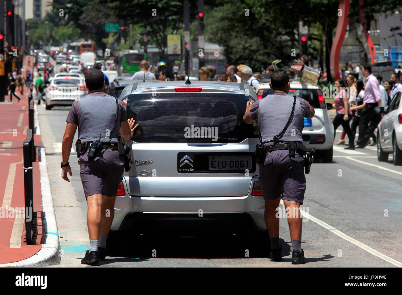 Policemen pushing broken down car on Paulista avenue at São Paulo city - Brazil Stock Photo
