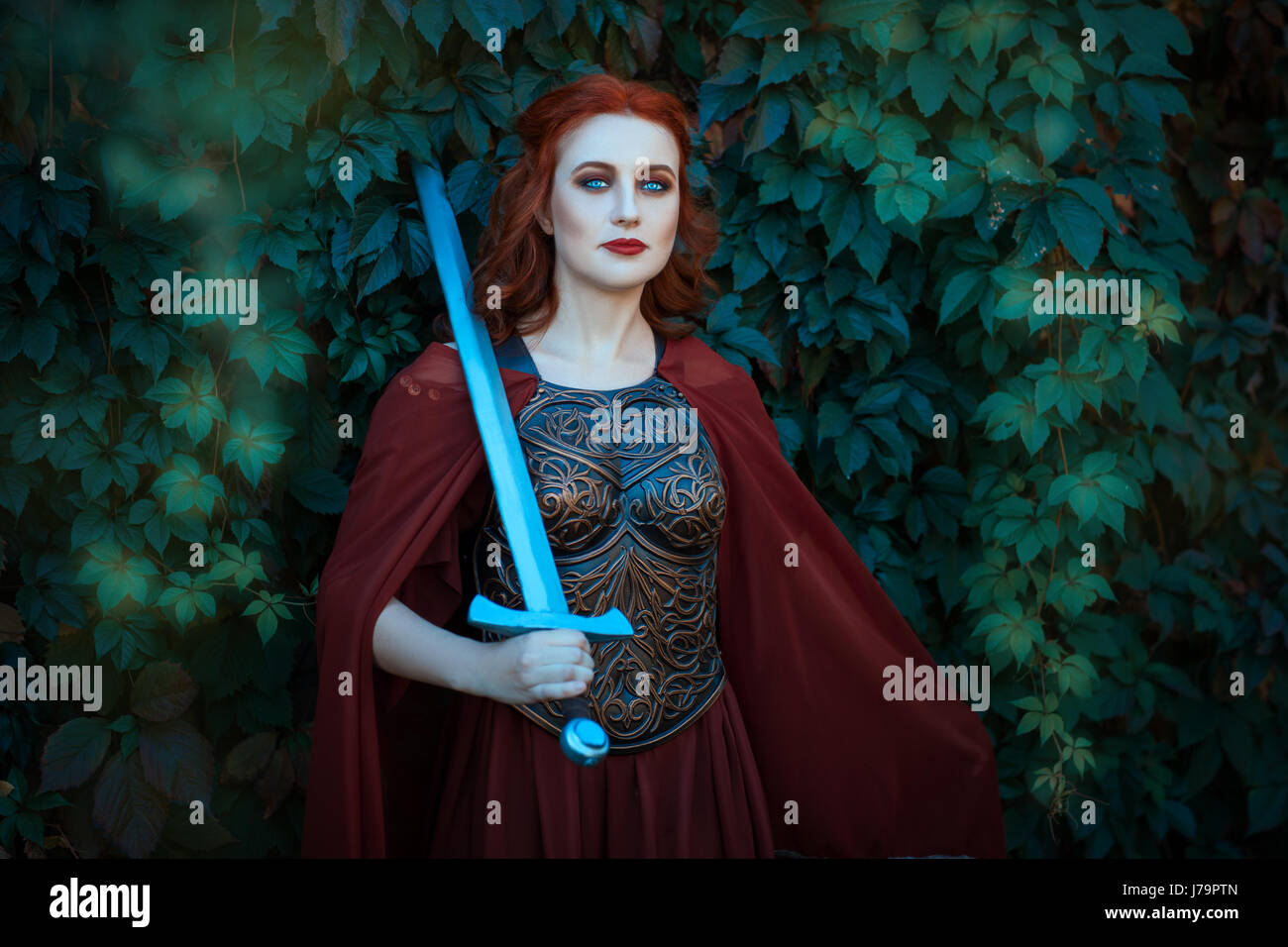 Woman warrior with sword wearing a cuirass. On the shoulders of her cloak. Stock Photo