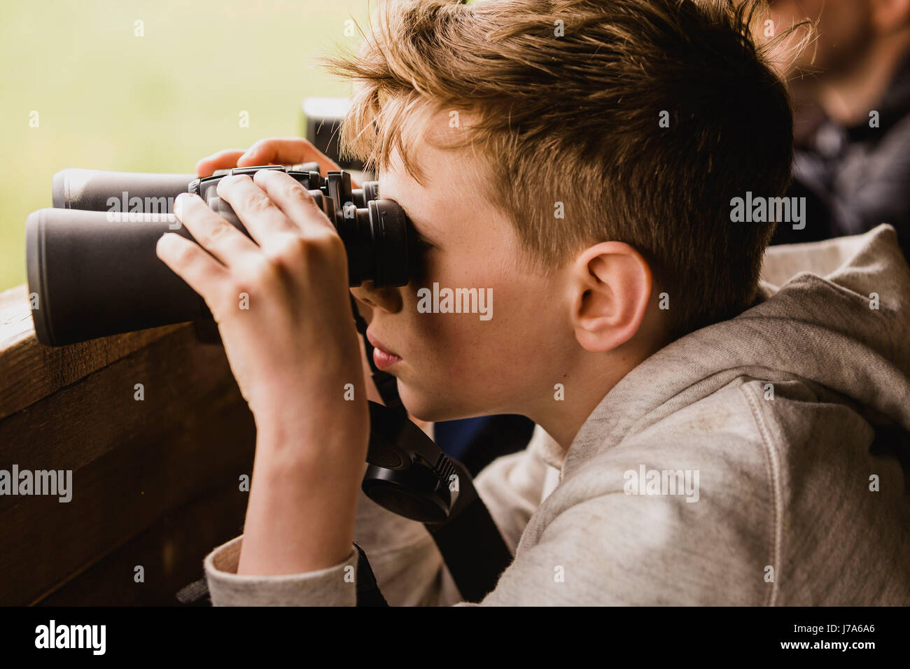 Boy birdwatching with binoculars Stock Photo