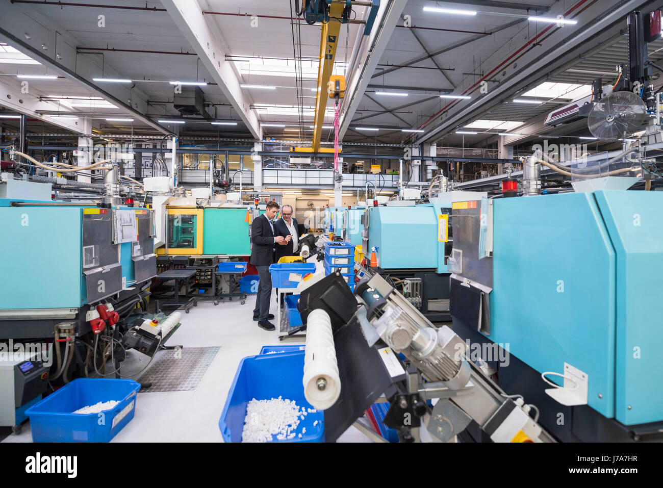 Two men talking in factory shop floor Stock Photo - Alamy