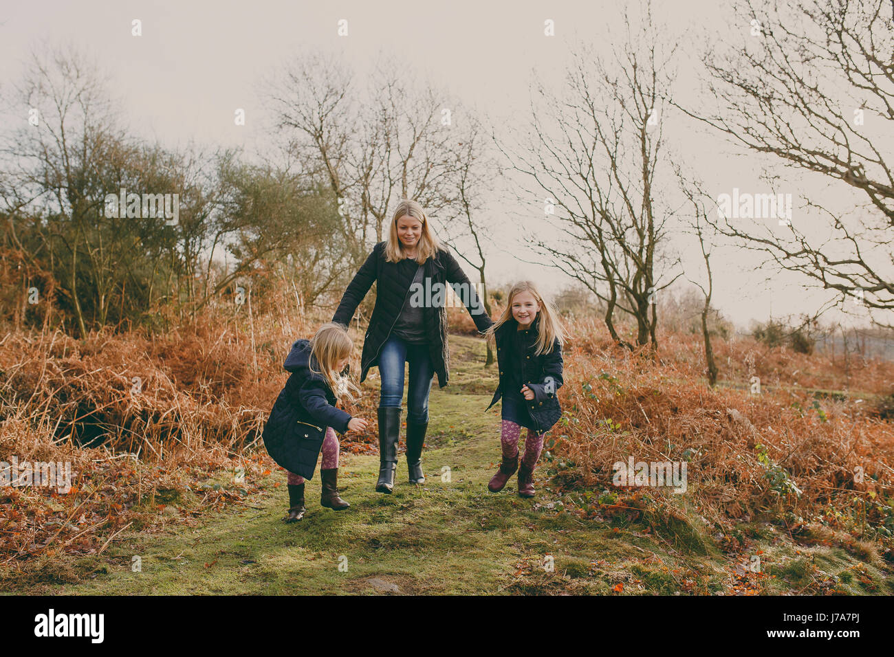 Mother and daughters running on a meadow together Stock Photo
