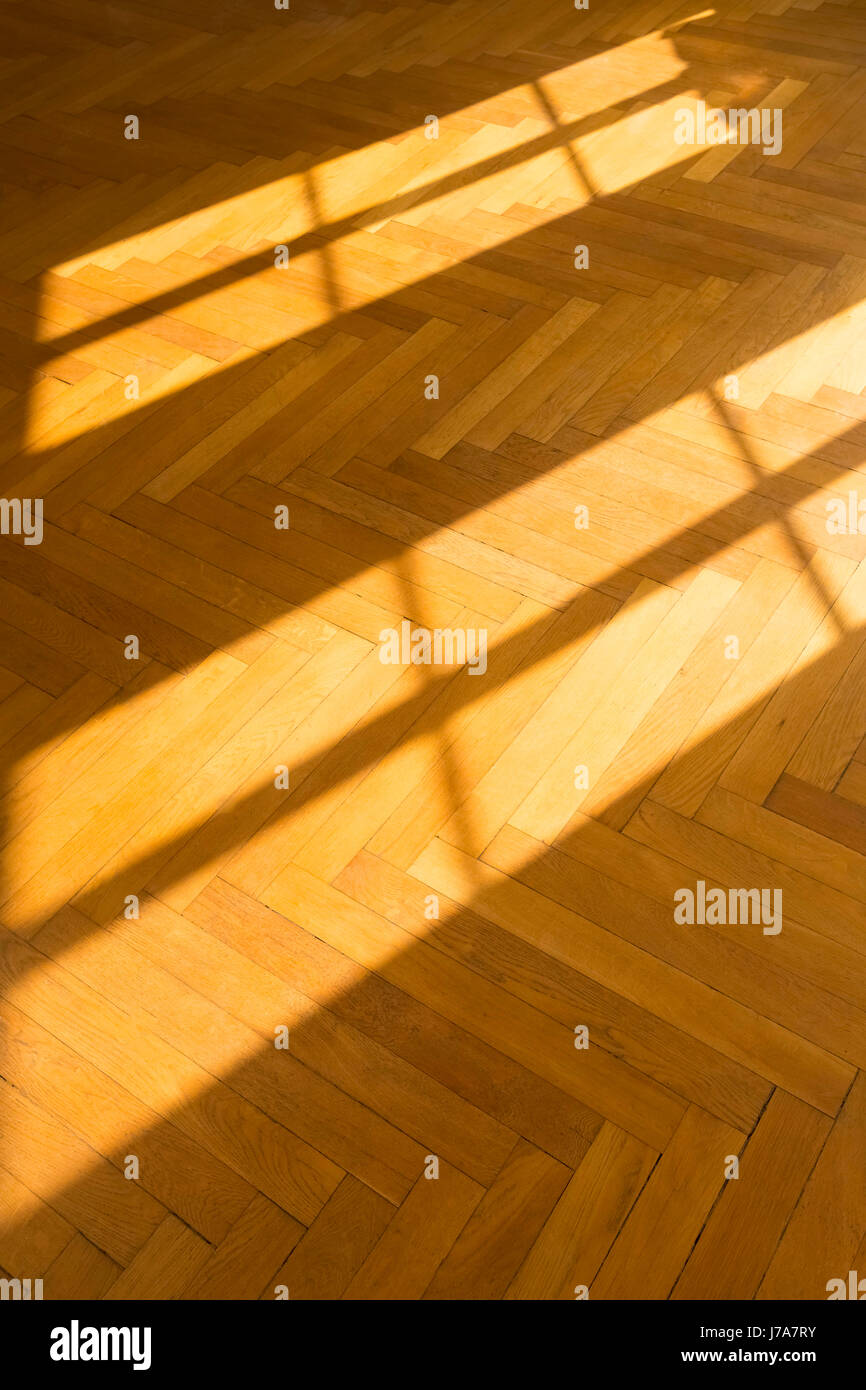 Shadow and light on herringbone parquet flooring Stock Photo