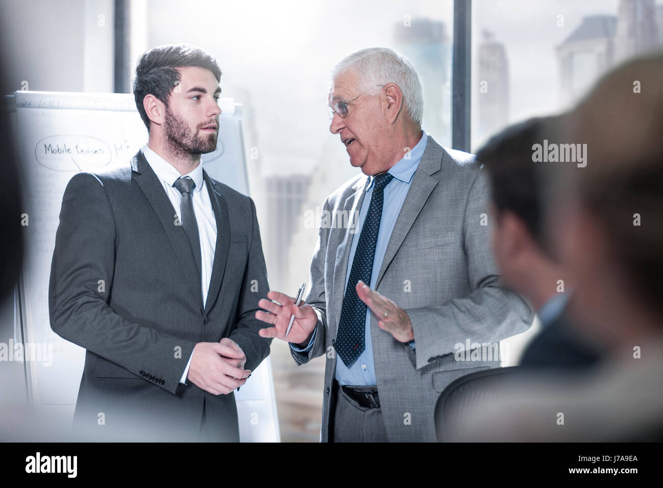Two businessmen talking in city office Stock Photo - Alamy