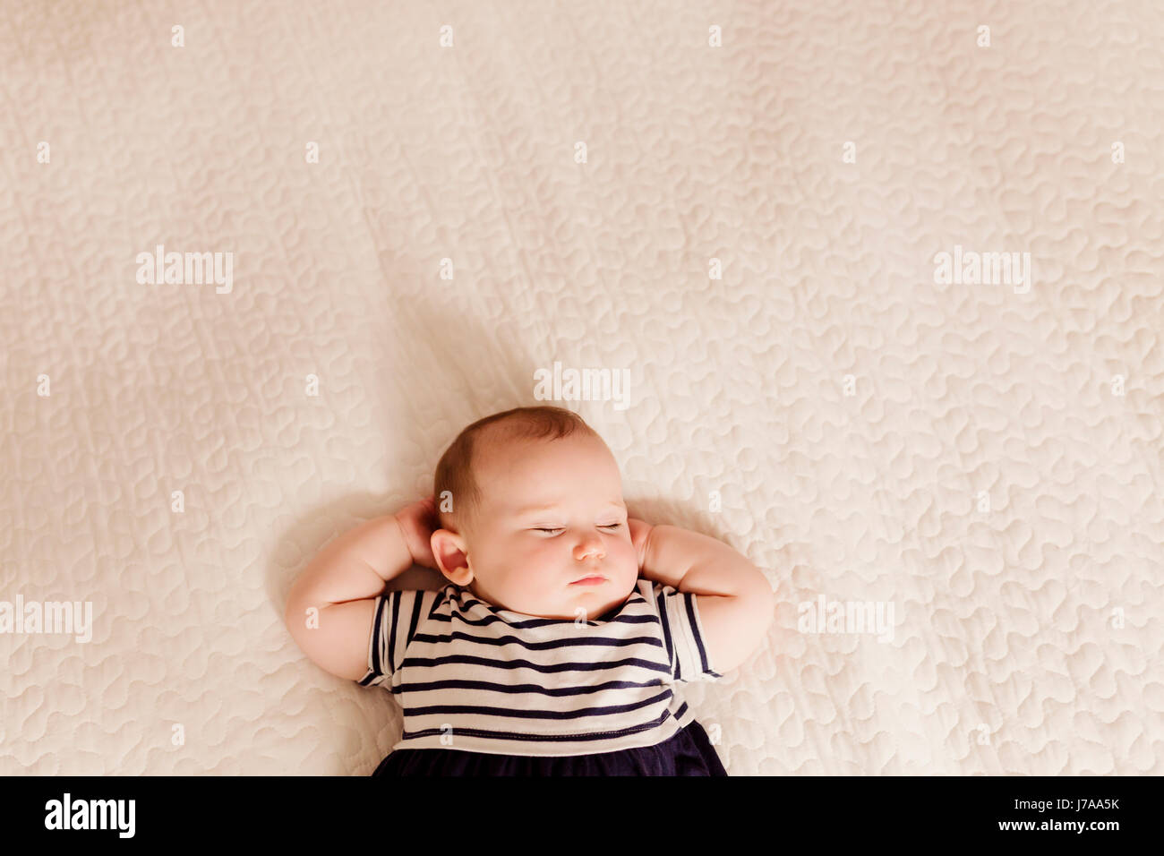 Portrait of baby girl sleeping on bed Stock Photo