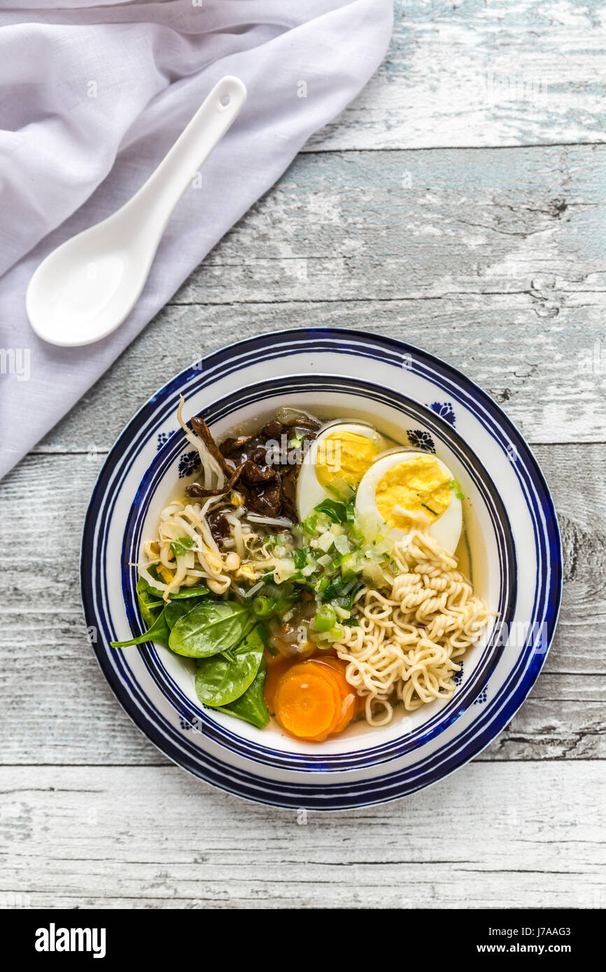 Bowl of ramen soup with spinach, carrot, boiled egg, bamboo sprouts and mushrooms Stock Photo