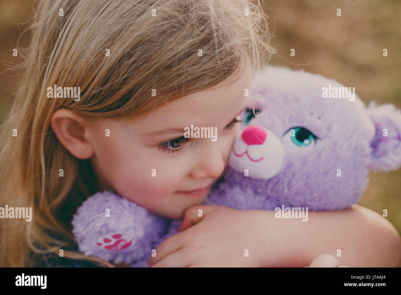 Girl cuddling a teddy Stock Photo