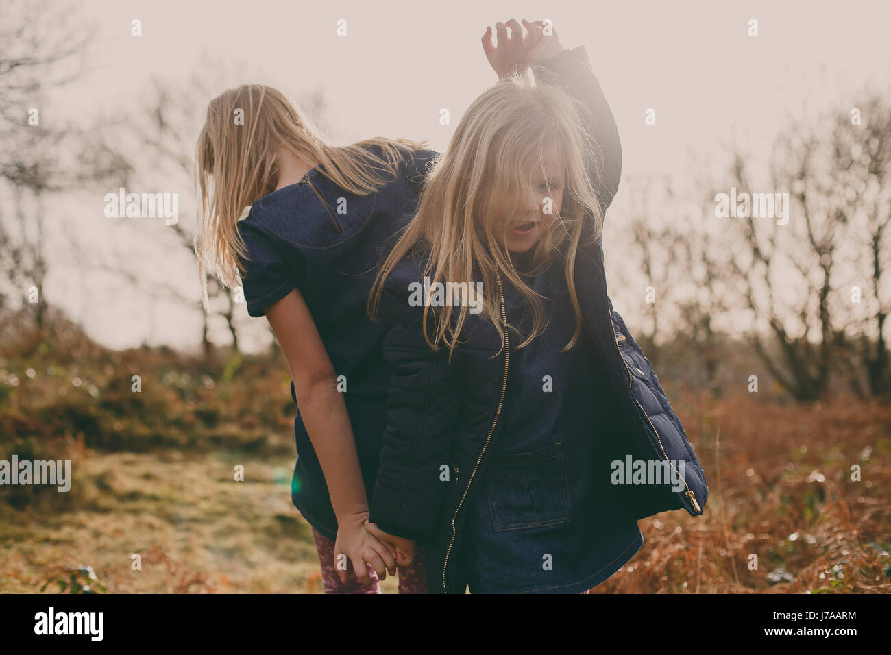 Two sisters dancing on a meadow Stock Photo