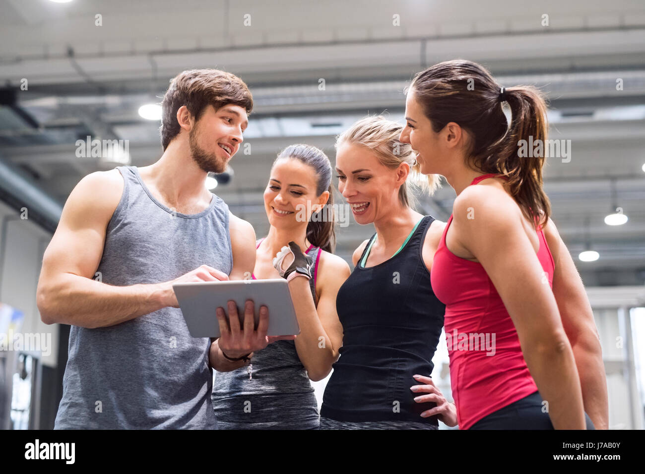 Group of happy athletes with tablet after exercising in gym Stock Photo ...