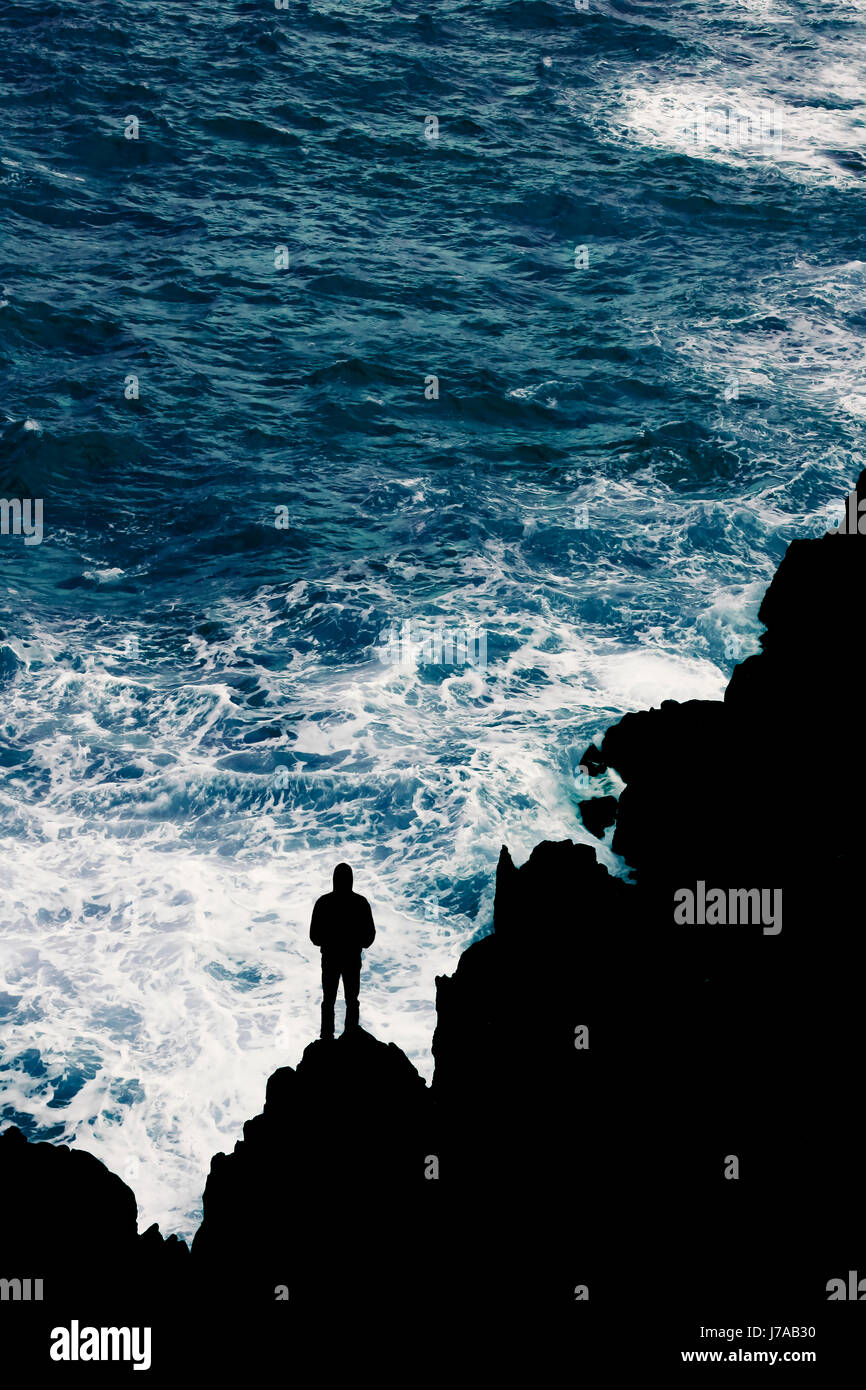 Mann vor aufgewühltem Meer auf Felsen stehend, Madeira, Portugal Stock Photo