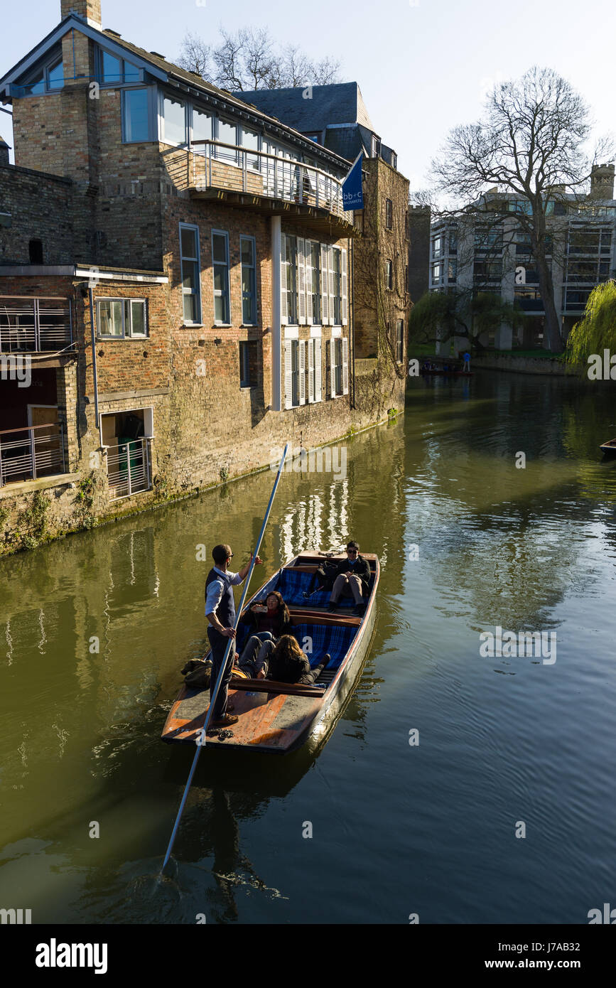 Tourists On A Punt Boat With Old Buildings Lining The River Cam On A Sunny Spring Day, Cambridge, United Kingdom Stock Photo