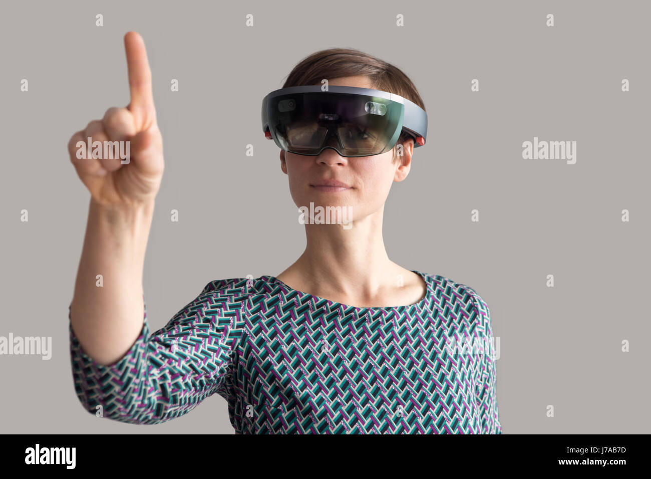 Woman wearing mixed reality smartglasses raising her hand Stock Photo