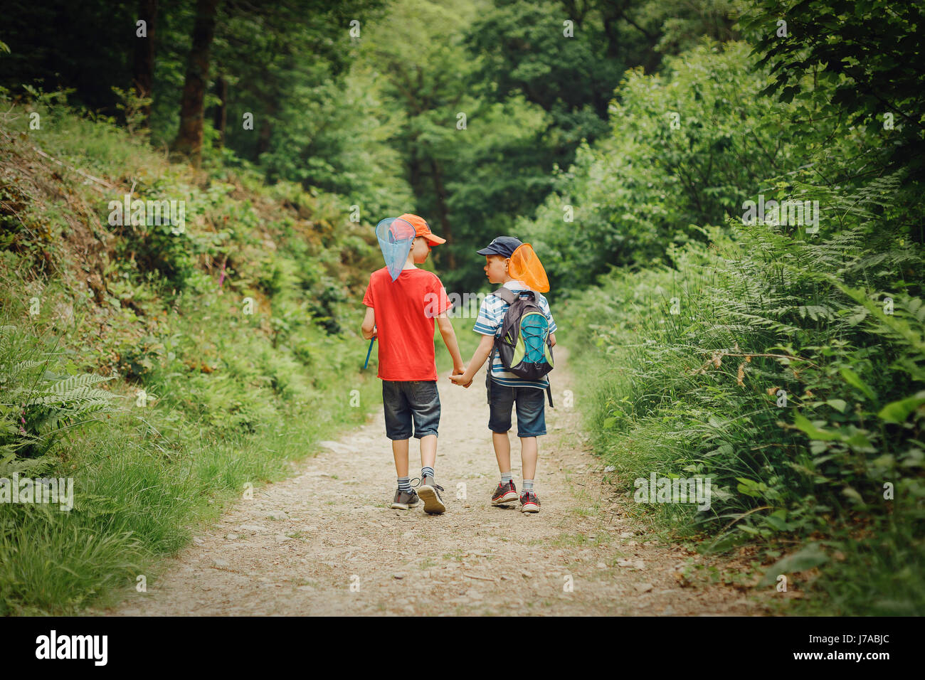 Two boys walking hand in hand with dip nets Stock Photo