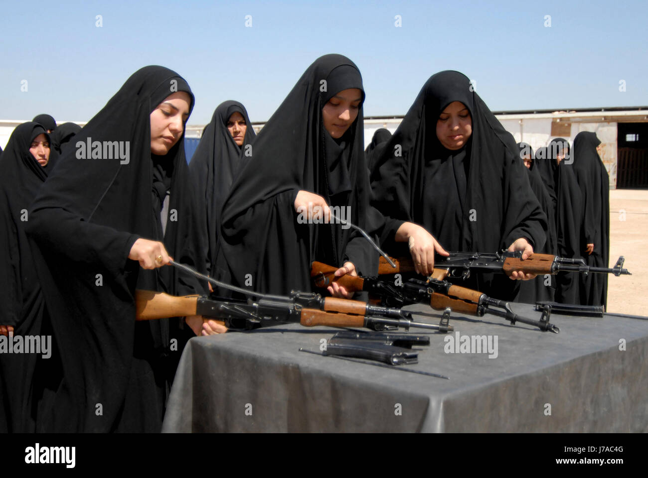 Iraqi female recruits disassemble AK-47 assault rifles during weapons training. Stock Photo