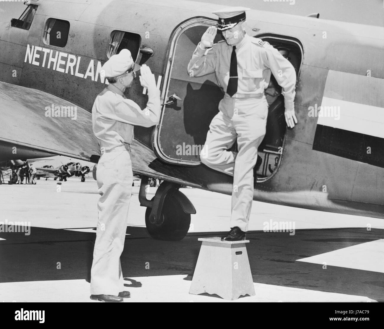 A Royal Netherlands Air Force  General exchanges salutes with a Brigadier General as he exits his aircraft, circa 1942. Stock Photo