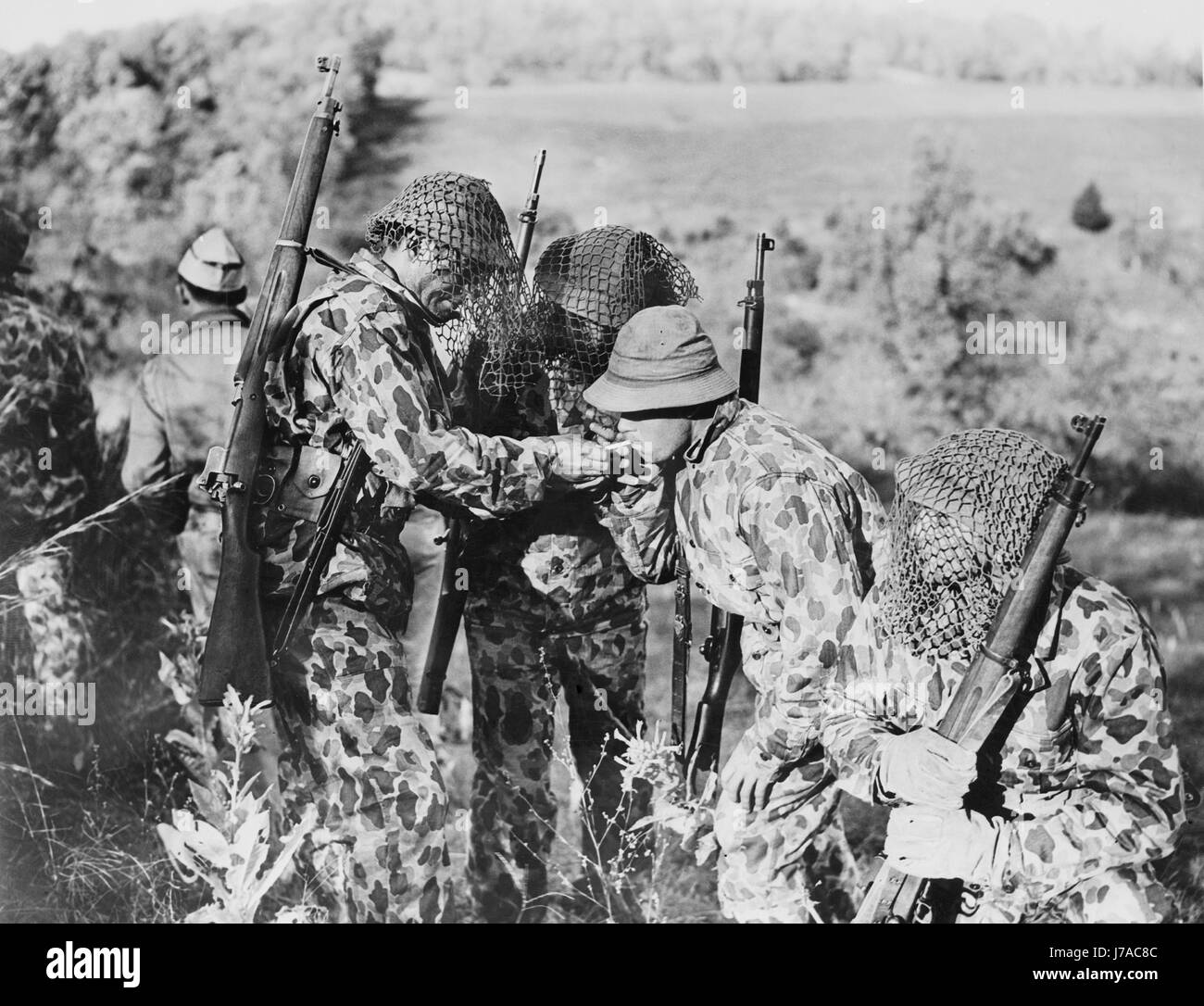 U.S. Army soldiers wearing leopard-spotted suits to blend into the landscape, circa 1942. Stock Photo