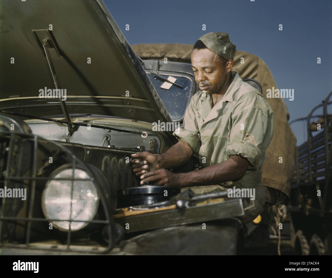 A colored mechanic doing maintenance on Army trucks, 1941. Stock Photo