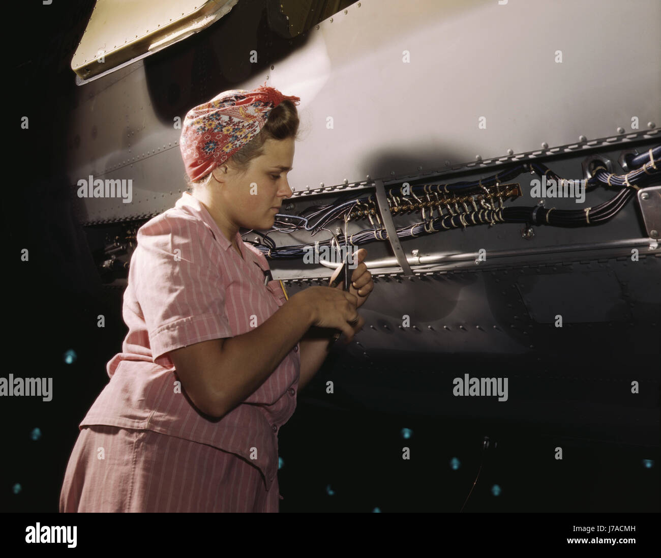 Woman doing electrical assembly and installation work at an aircraft assembly plant, 1942. Stock Photo