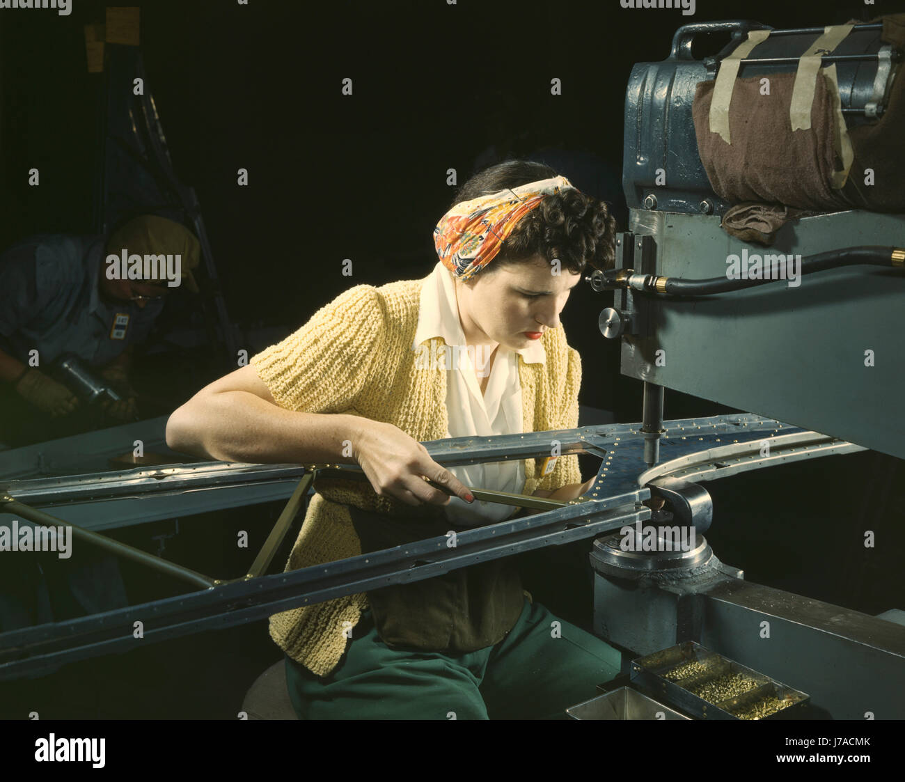 A woman riveting machine operator at an aircraft assembly plant during WWII, 1942. Stock Photo