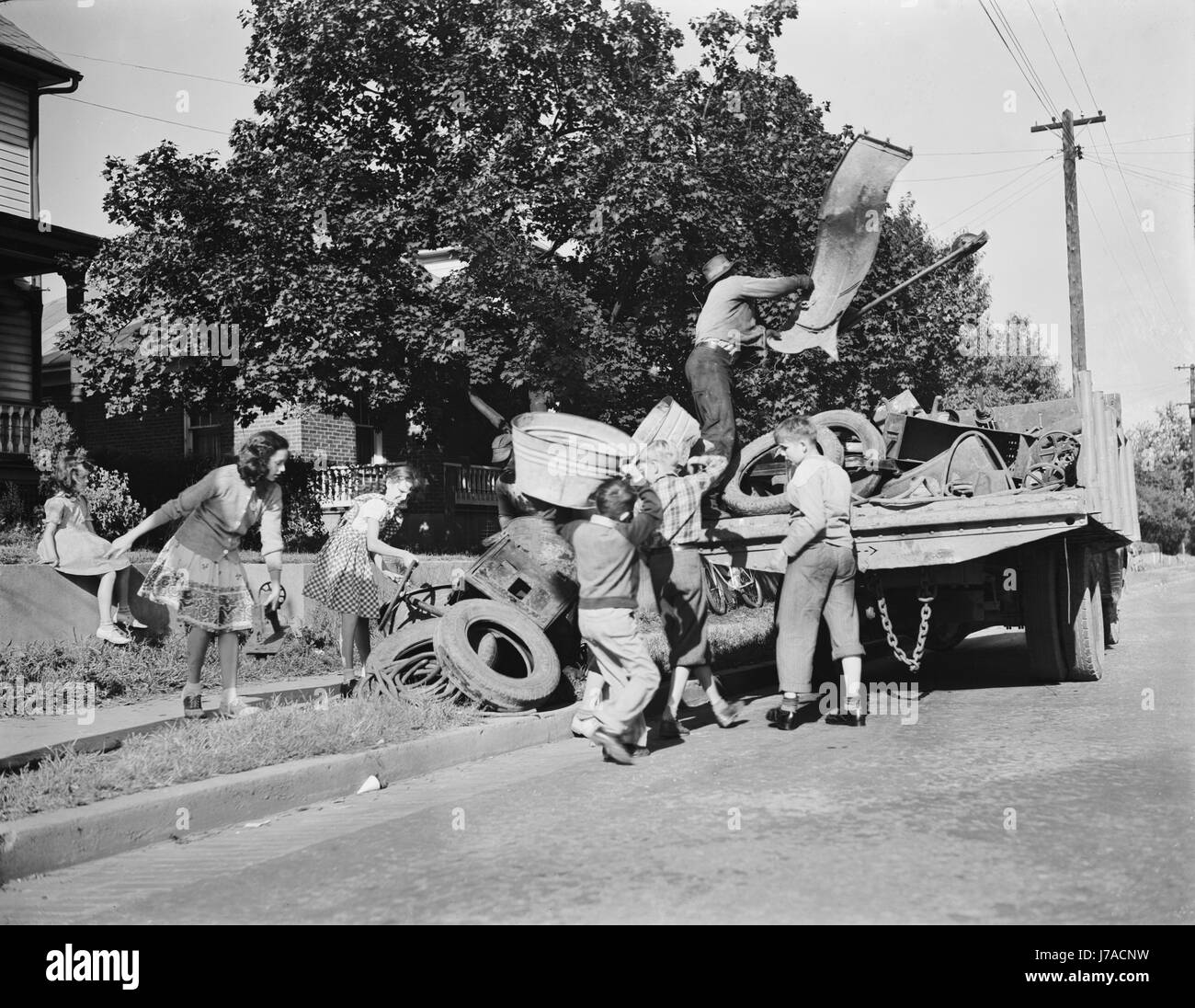 Youngsters help load a truck with scrap metal for donation to their war industries, 1942. Stock Photo