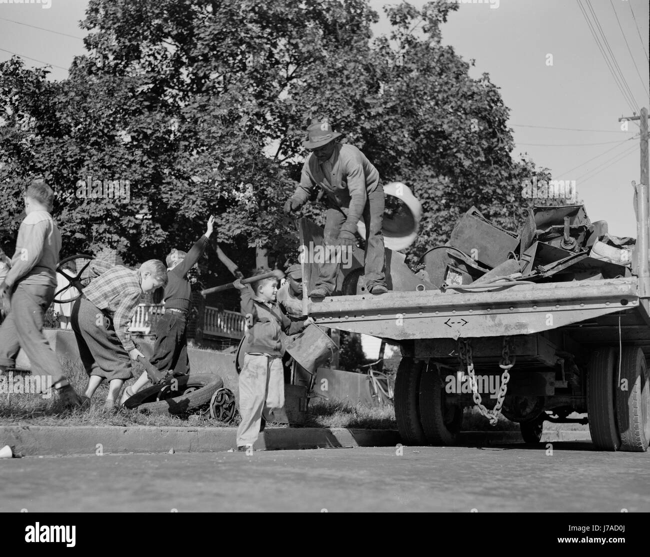 Youngsters help load a truck with scrap metal for donation to their war industries, 1942. Stock Photo