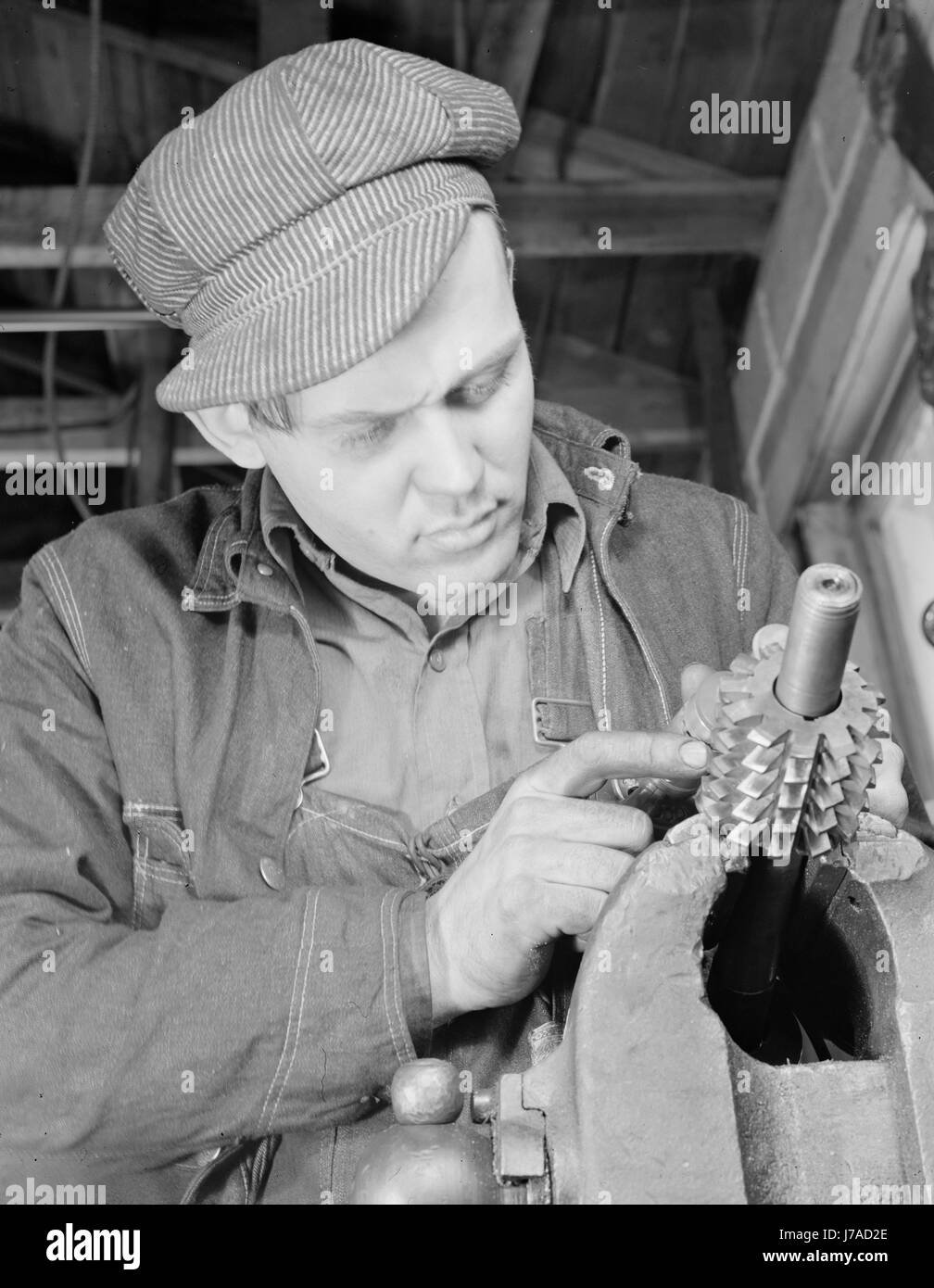 Man working in a small machine shop for war production, circa 1942. Stock Photo