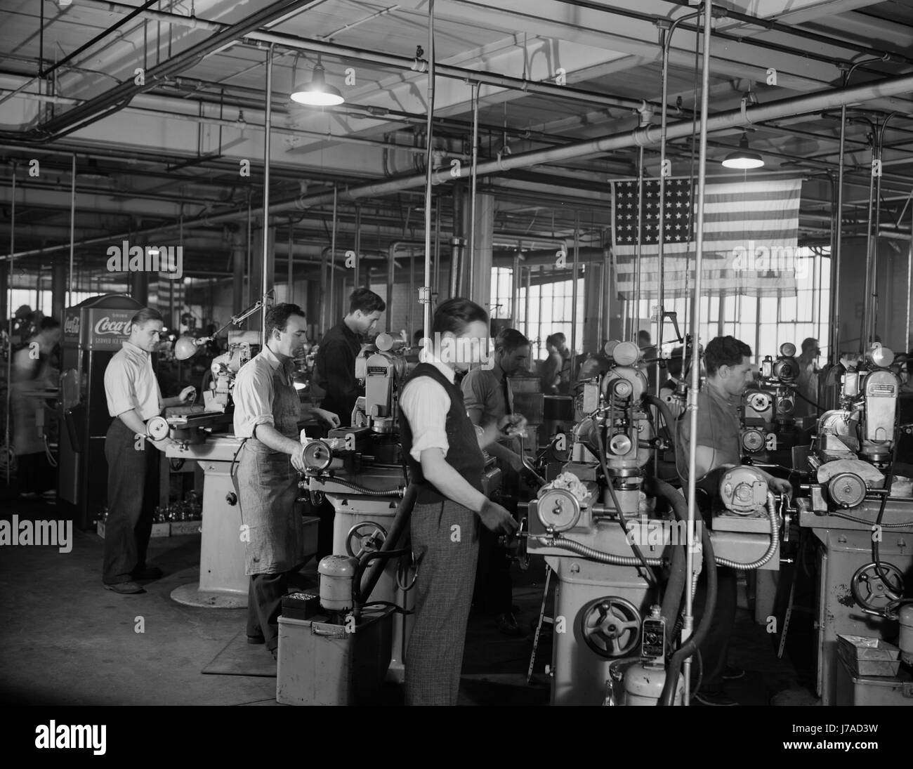 Factory workers grinding small parts for machine tools to aid the war production effort, 1942. Stock Photo