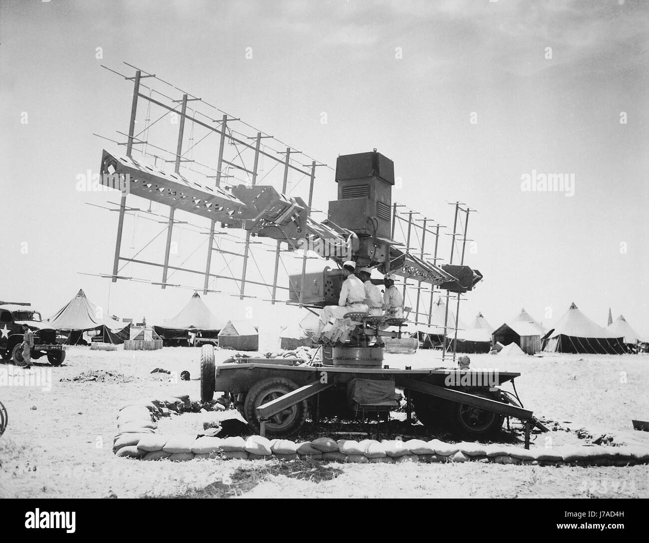 Three soldiers of the U.S. Army sit in place at a SCR-268 radar during World War II. Stock Photo